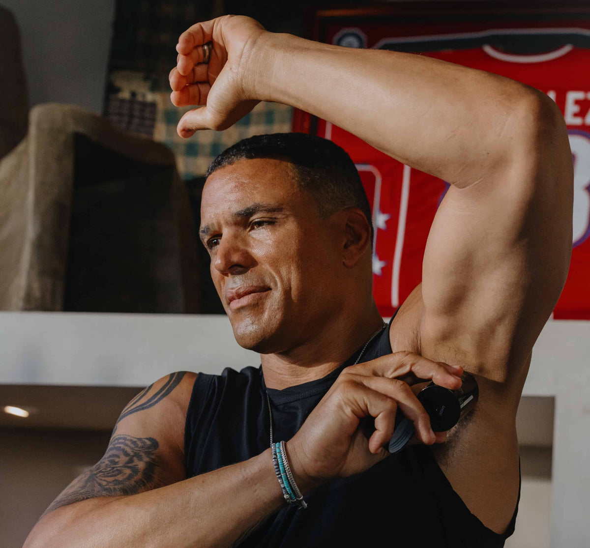 Caldera + Lab Chief Wellness Ambassador Tony Gonzalez applying deodorant