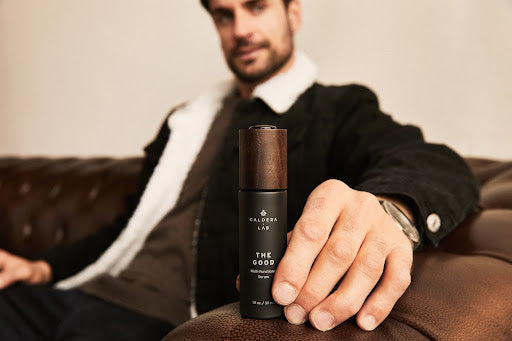 Man holding a bottle of dermatologically tested Caldera Lab Multi Functional Serum