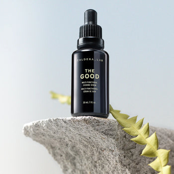 The Good Multi-Functional Serum on a rock with greenery