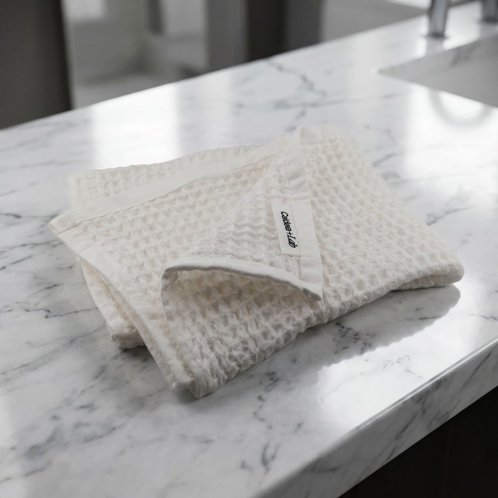 Folded textured face towel  on a marble bathroom counter.