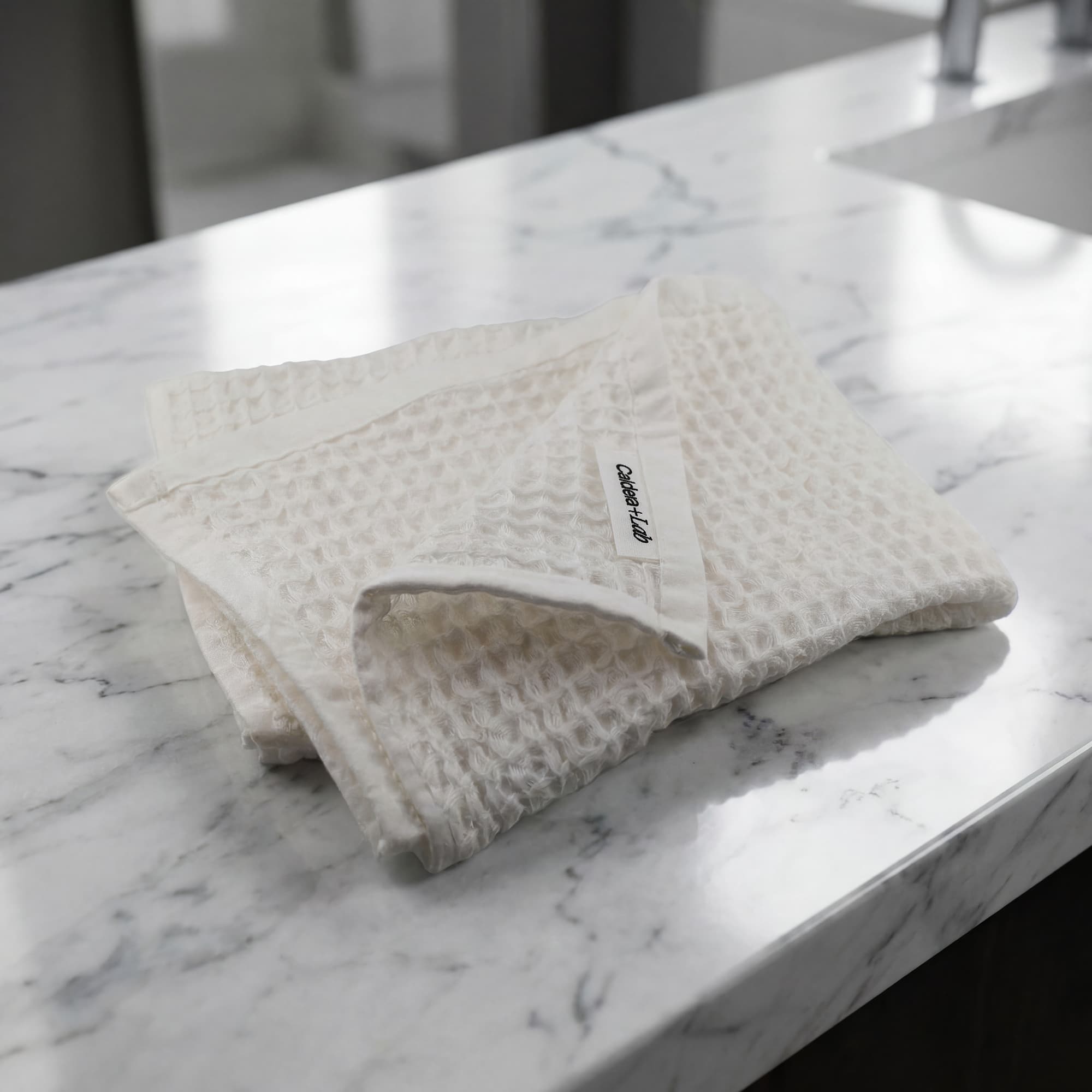 Folded textured face towel  on a marble bathroom counter.
